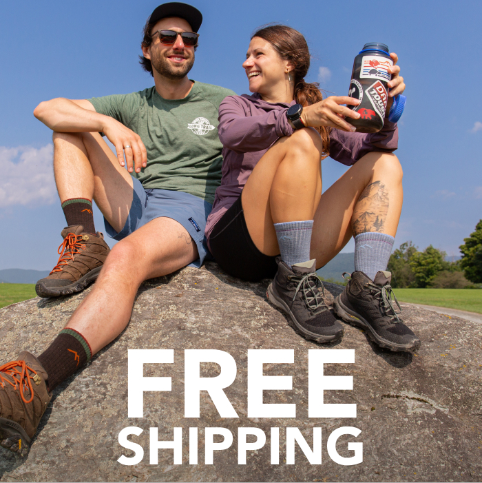 Shop with FREE SHIPPING - a man and woman sit on a rock, wearing Darn Tough hiking socks