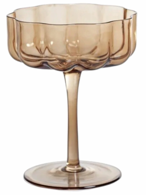 Amber-tinted coupe glass with a scalloped bowl and slender stem, shown against a white background. Fearrington Village.