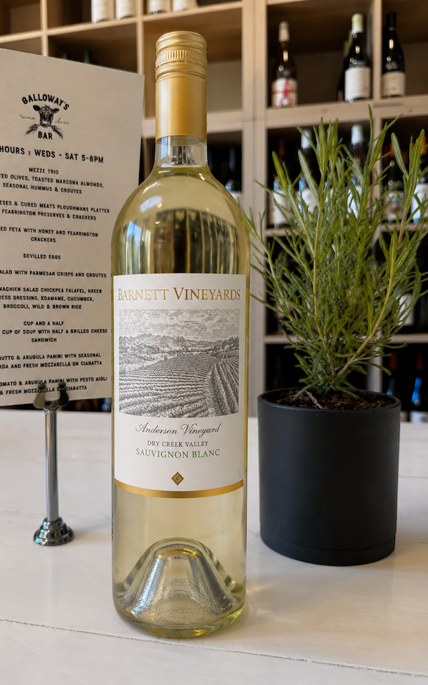 Barnett Vineyards Sauvignon Blanc displayed on a table at Galloway's Wine Bar with a menu and rosemary plant, Fearrington Village.