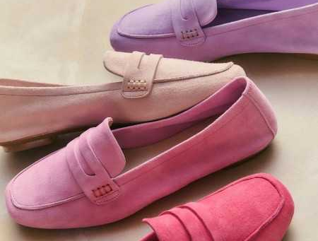 Close-up of suede loafers in soft pink, rose, and lavender tones, layered slightly to showcase color variation and smooth suede finish.