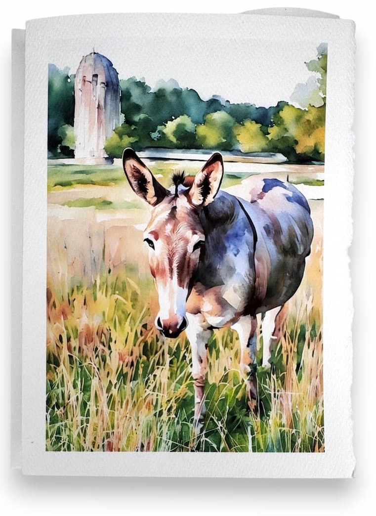 Watercolor-style card featuring a donkey standing in tall grass, with a rustic silo and tree line in the background, printed on textured paper with soft, deckled edges.