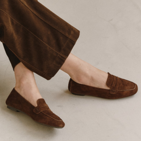 Brown suede penny loafers styled with coordinating brown trousers. Fearrington Village.