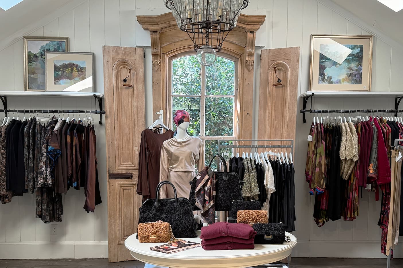Fall fashion and accessories displayed among clothing racks inside Dovecote Style. Fearrington Village.