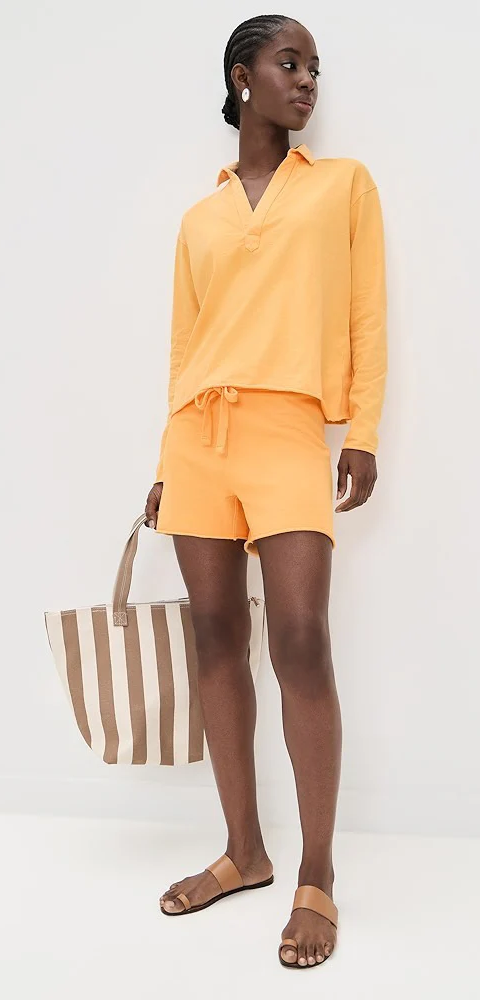 Woman wearing a yellow lounge set with a striped tote bag and leather sandals. Fearrington Village.