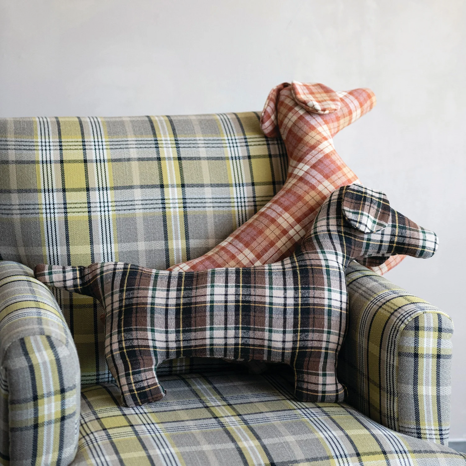 Two plaid fabric dog-shaped decorative pillows on a matching tartan armchair. Fearrington Village.