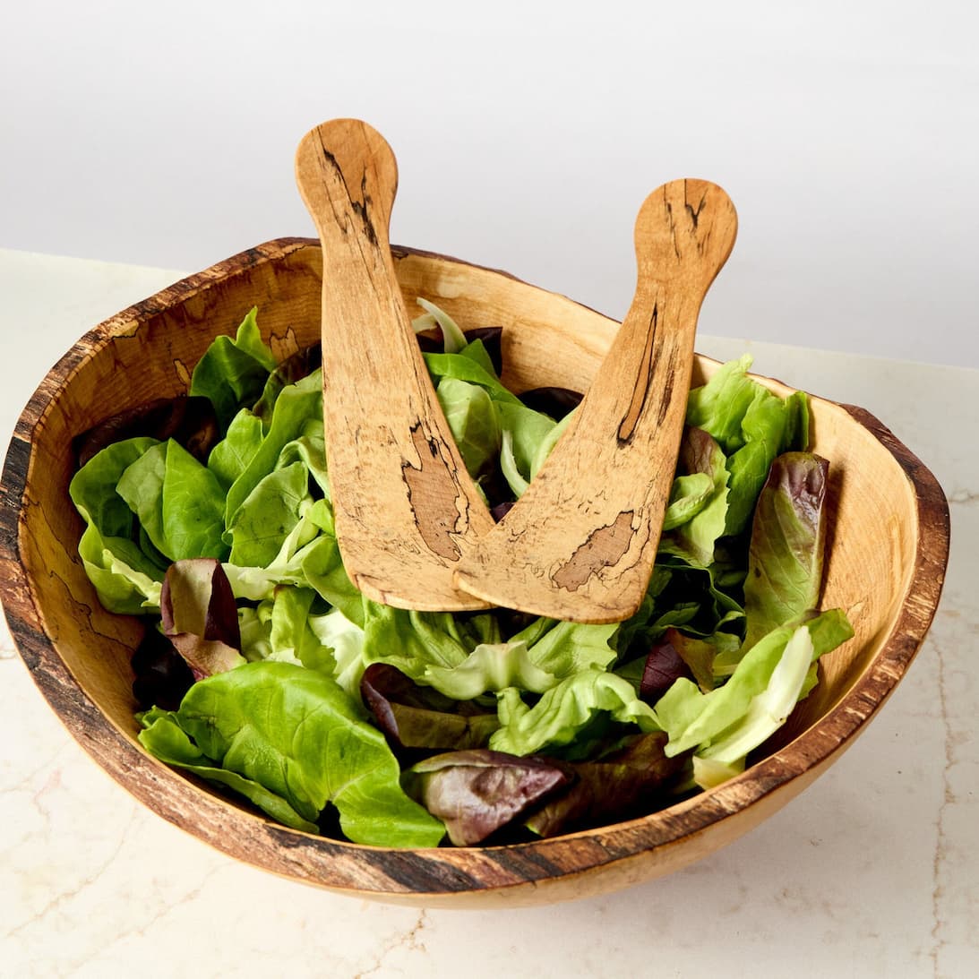 Handcrafted wooden salad bowl with matching servers and fresh greens. Fearrington Village.