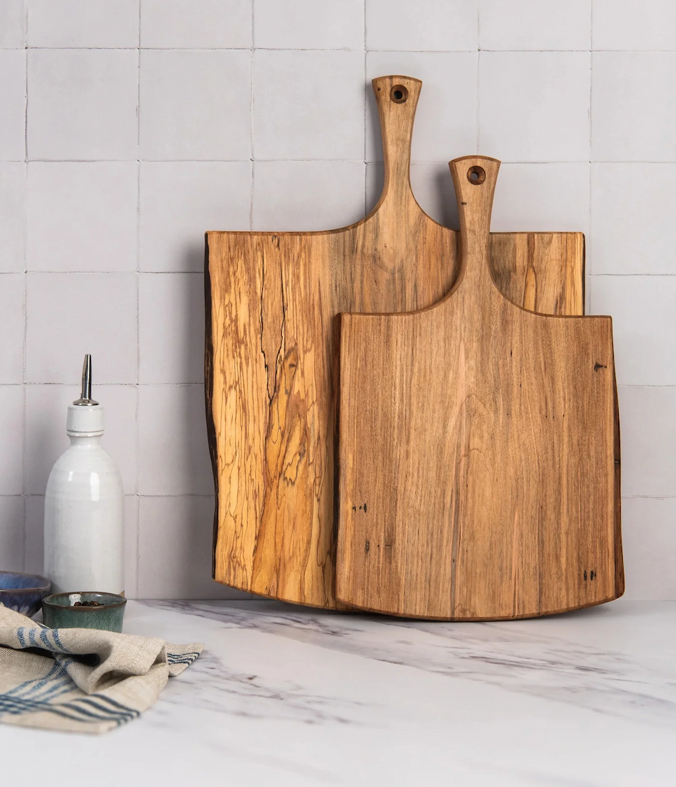 Two handcrafted wooden serving boards with natural grain displayed in a bright kitchen. Fearrington Village.