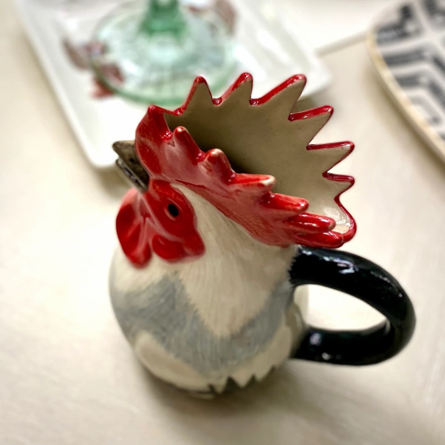 Ceramic rooster mug with a bright red comb and black handle. Fearrington Village.