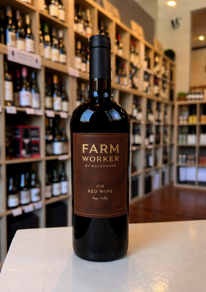 Farm Worker by Maldonado 2018 red wine bottle displayed on a white counter with wine shelves at Gallowy's Wine & Beer Bar in the background.