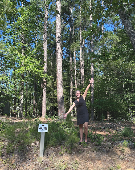 Laura Morgan standing on a wooded homesite in Fearrington Village.