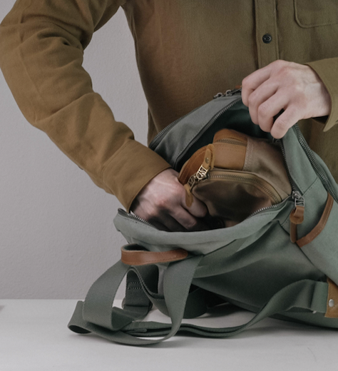 Person packing a travel bag with an organized toiletry kit. Fearrington Village.