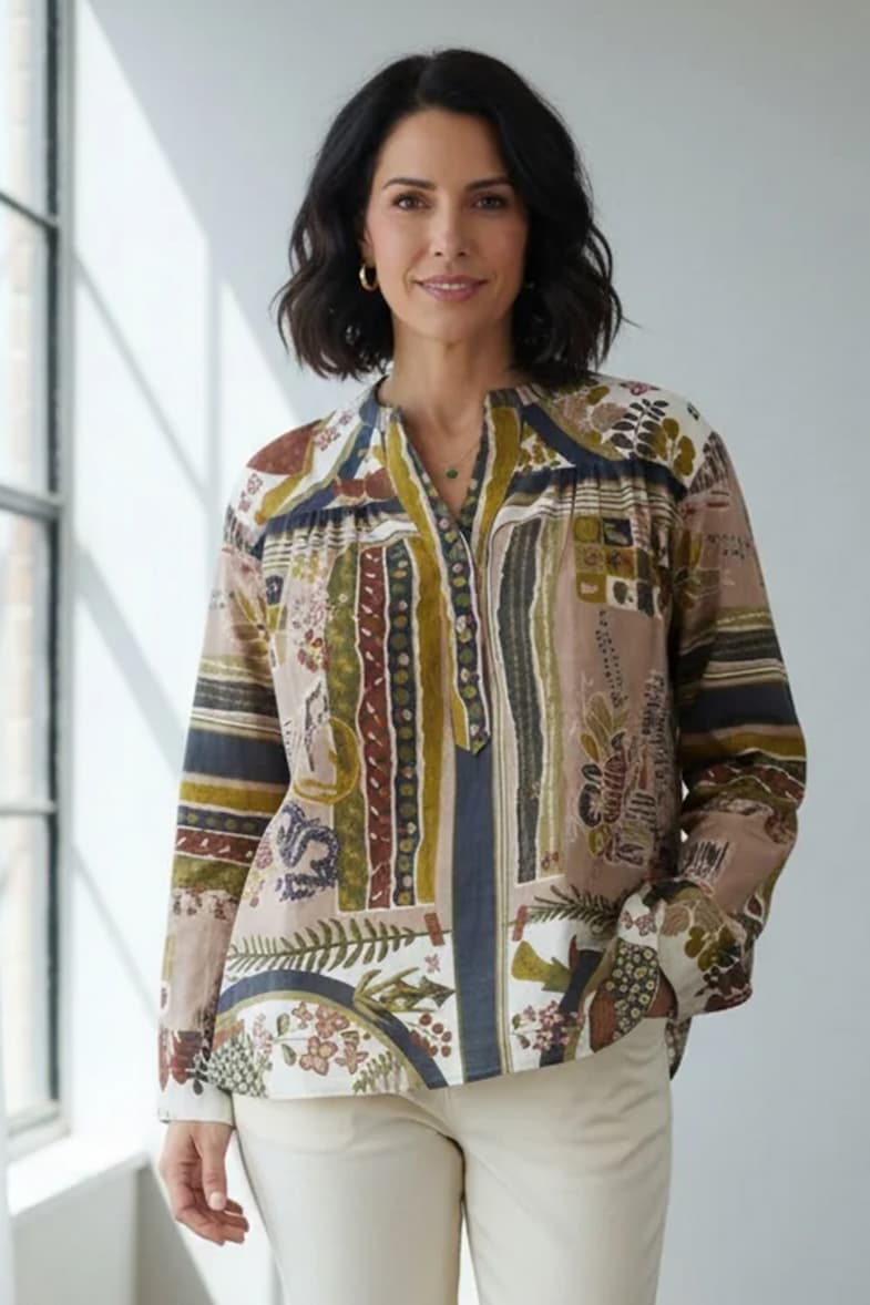 Woman wearing a colorful botanical-print blouse with cream trousers. Fearrington Village.