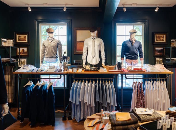 Men’s clothing and accessories displayed on mannequins and racks inside Thistle & Oak at Fearrington Village.