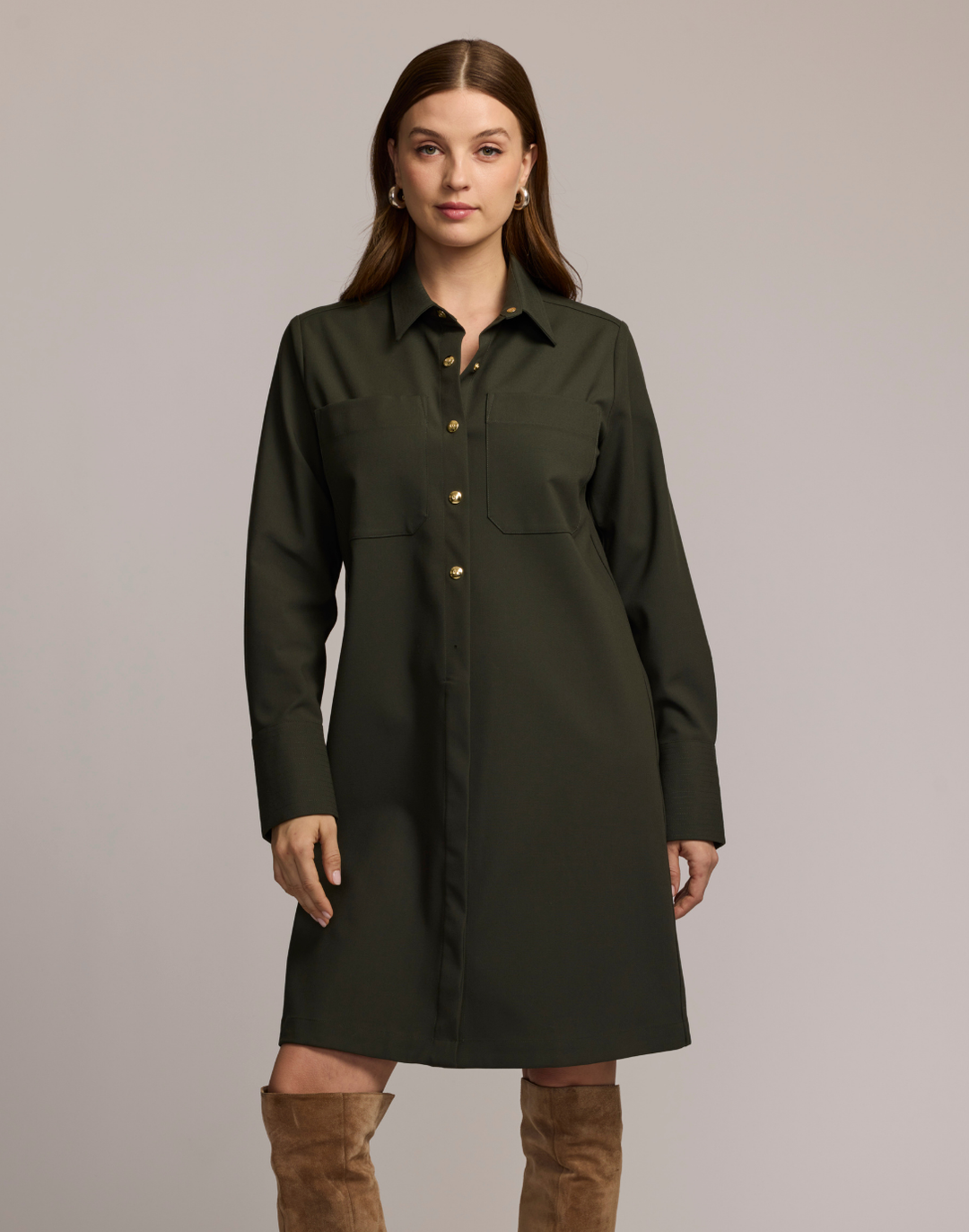 Model wearing a dark olive button-front shirt dress with gold buttons and chest pockets.