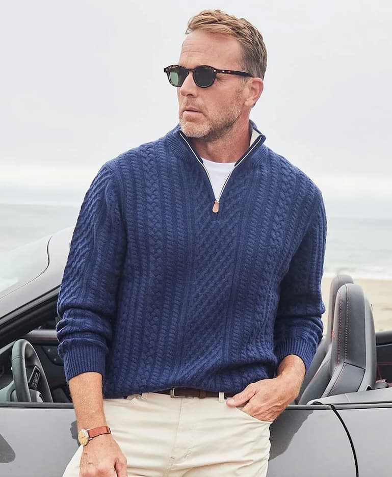 man in sunglasses wearing a navy quarter zip sweater