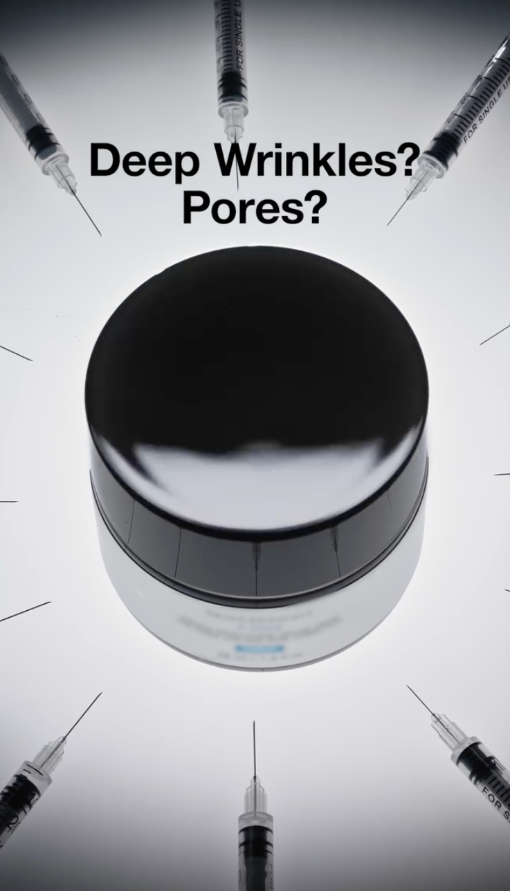 Dramatic product image of a skincare cream jar viewed from above against a bright white background. Multiple syringe needles point inward toward the jar, while bold text reads “Deep Wrinkles? Pores?” The composition visually references injectable cosmetic treatments and positions the cream as an alternative solution for reducing the appearance of wrinkles and enlarged pores.