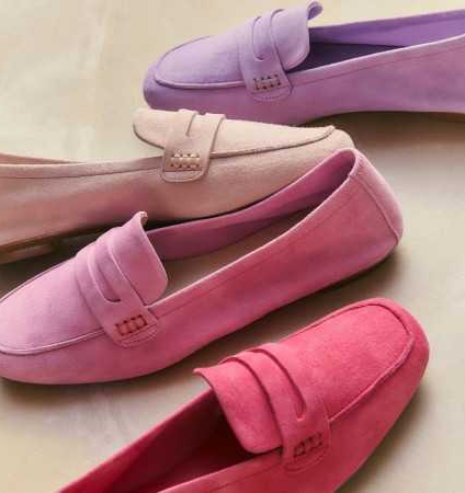 Close-up of suede loafers in soft pink, rose, and lavender tones, layered slightly to showcase color variation and smooth suede finish.