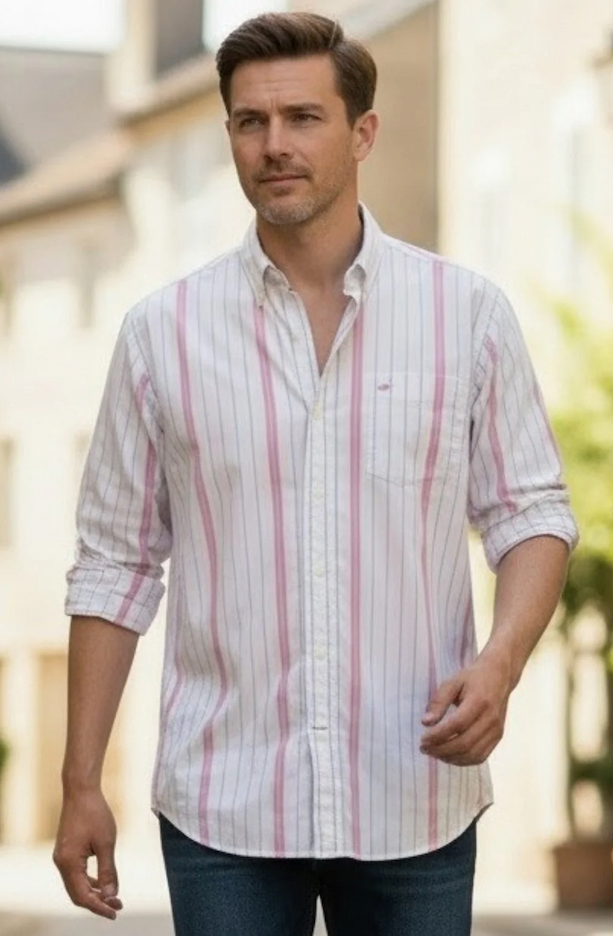 Man wearing a white striped button-down shirt with rolled sleeves and dark jeans. Fearrington Village.