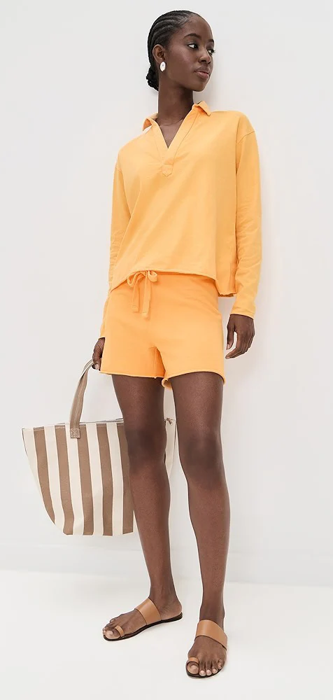 Woman wearing a yellow lounge set with a striped tote bag. Fearrington Village.