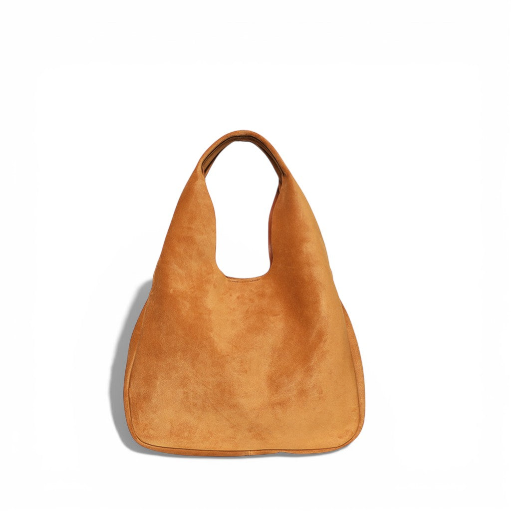 Warm tan suede hobo-style handbag with a soft, slouchy silhouette and integrated wide shoulder strap, featuring a minimalist, unstructured design and a rich, velvety texture.