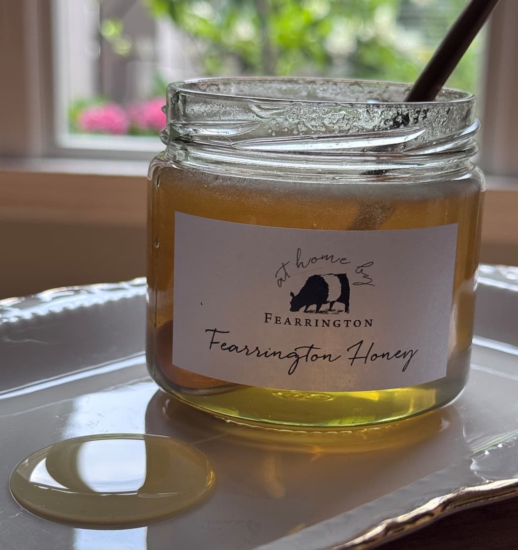 Jar of Fearrington honey with a honey dipper on a plate, Fearrington Village.
