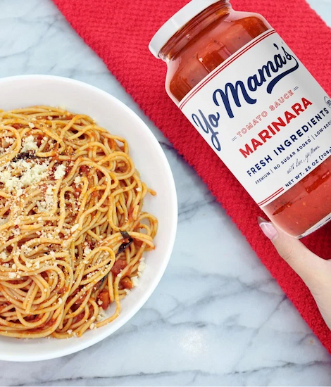 Jar of Yo Mama’s marinara sauce beside a bowl of spaghetti topped with grated cheese. Fearrington Village.