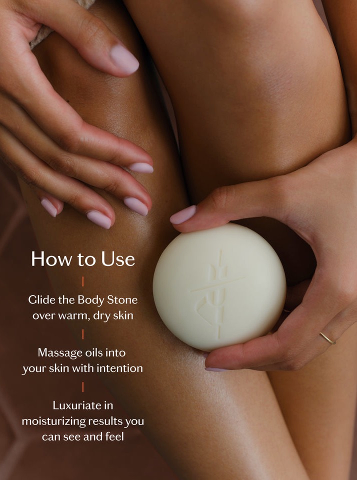 A person holds a round body stone and glides it over their leg. Text reads: "How to Use: Glide the Body Stone over warm, dry skin. Massage oils into your skin with intention. Luxuriate in moisturizing results you can see and feel. Fearrington Village