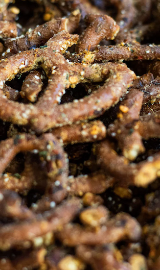 Close-up of seasoned pretzel sticks coated with spices and herbs.