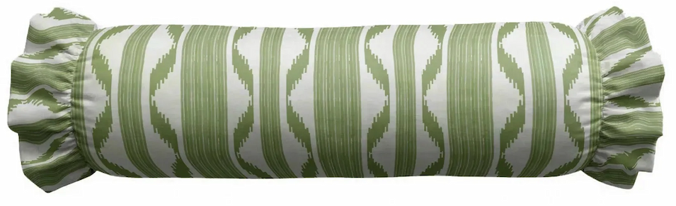 Green and white patterned bolster pillow with decorative ruffled ends on a white background. Fearrington Village.