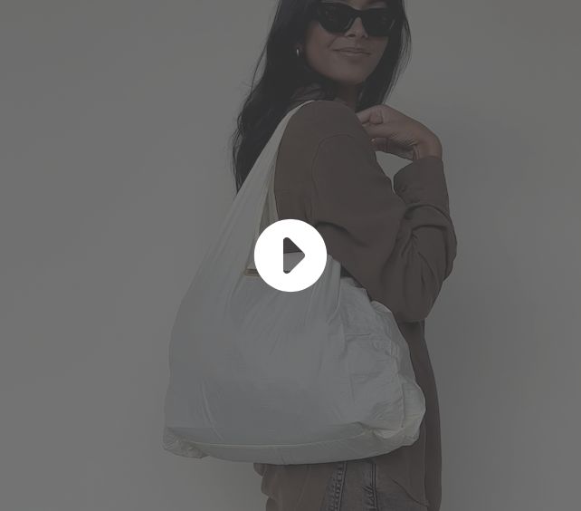 video showing a woman unfurling and using the convertible tote bag