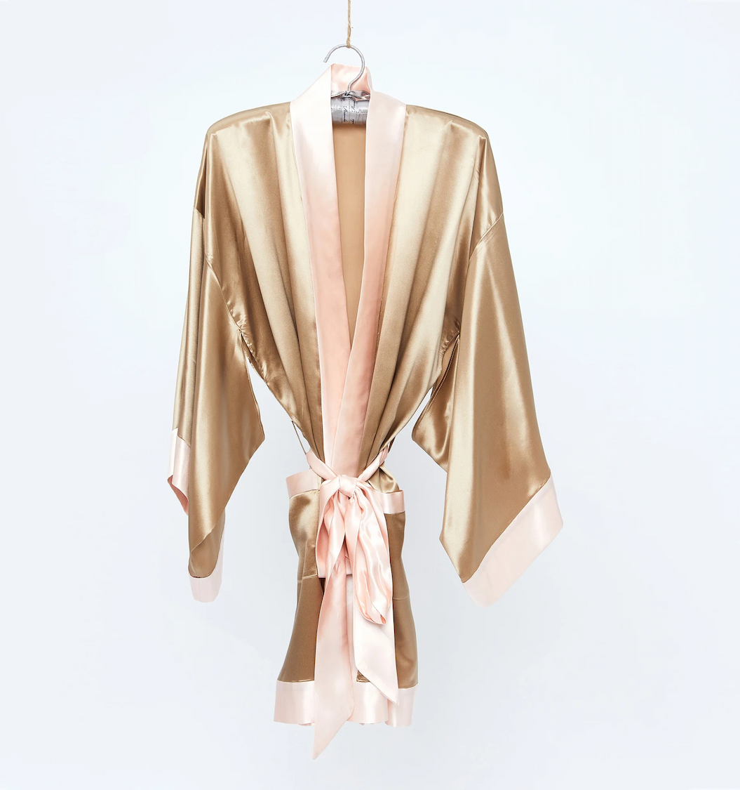 Champagne satin spa robe with blush trim hanging on display at Fearrington Village.
