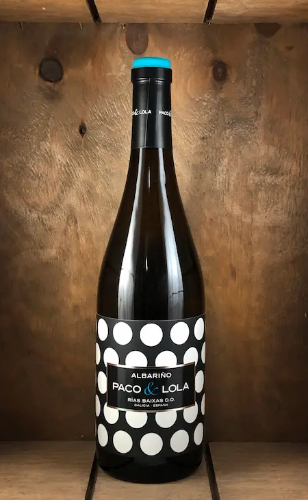 Bottle of Paco & Lola Albariño white wine with its signature black-and-white polka dot label. Fearrington Village.