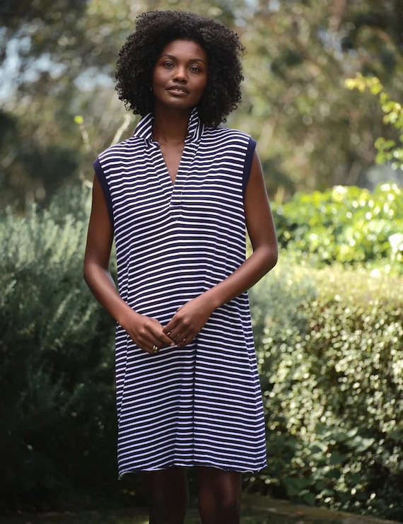 Navy and white striped sleeveless shift dress with a standing collar, shown outdoors in a garden setting. Fearrington Village.
