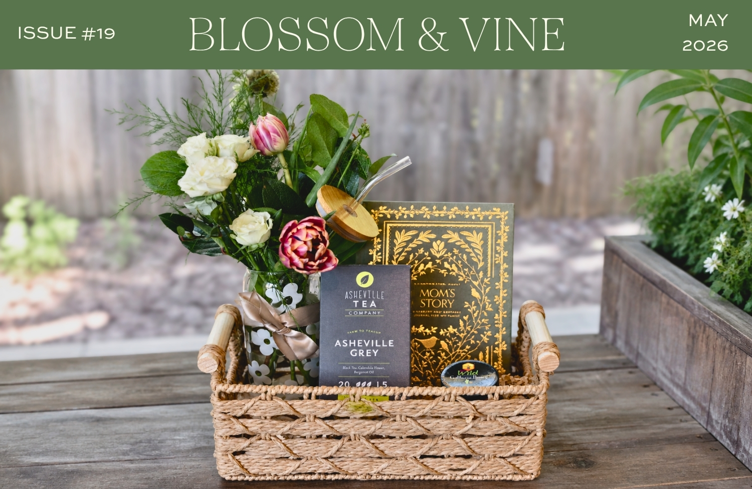May 2026 Blossom & Vine newsletter cover featuring a Mother's Day gift basket with flowers, tea, honey, and a keepsake book