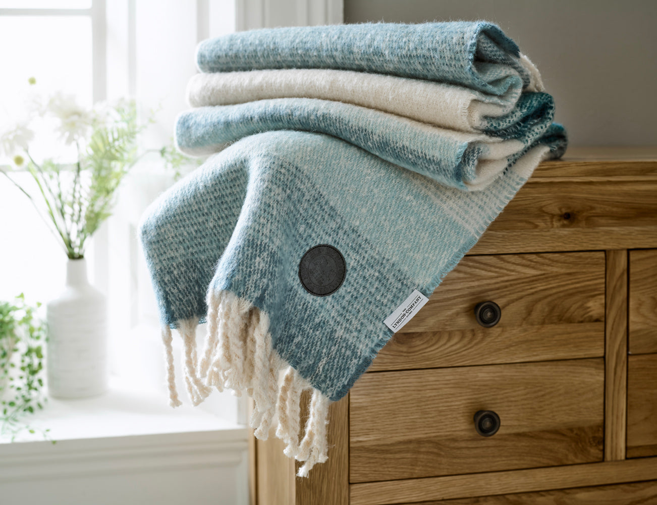 Cosy grey throw blanket draped over a bed from Deyongs