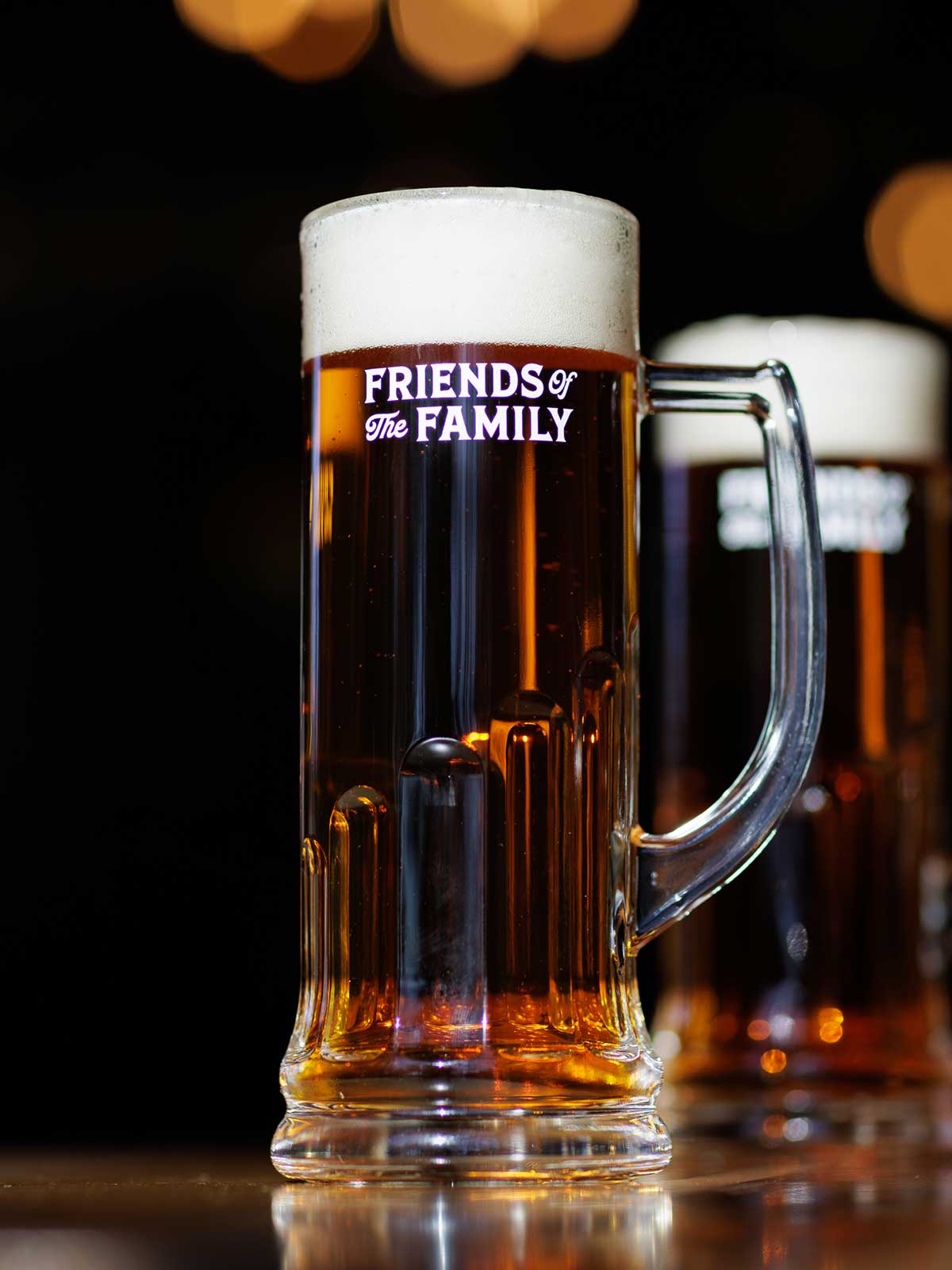 A Friends of the Family membership mug filled with beer