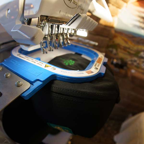 A hat getting a custom design on an embroidery machine