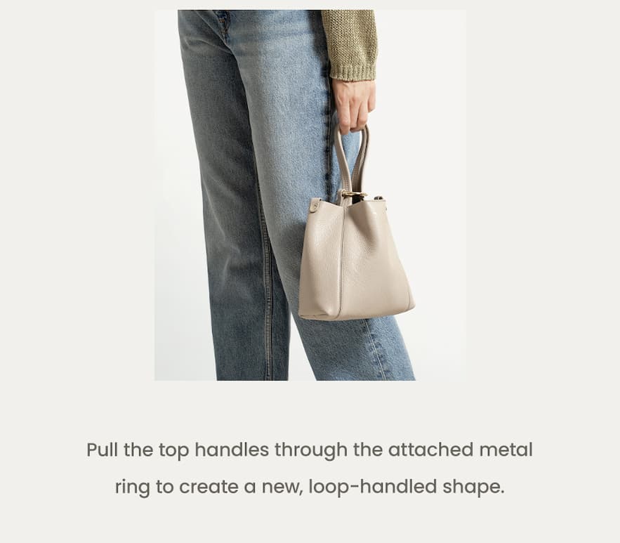 Pull the top handles through the attached metal ring to create a new, loop-handled shape.   The Lola Small Tote 