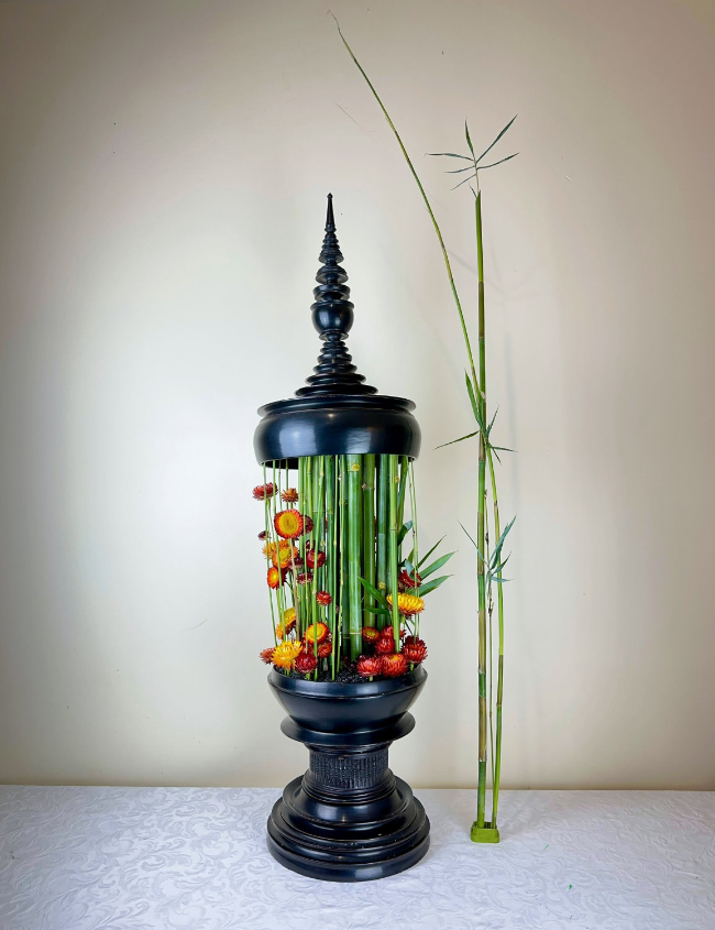An arrangement of Bamboo & Strawflowers in a Burmese offering bowl