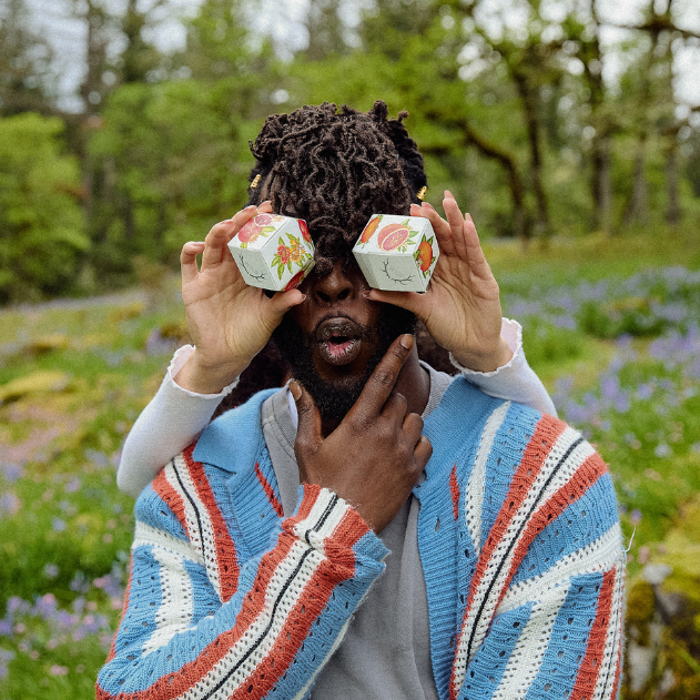 Two packages of wyld gummies covering eyes of a man