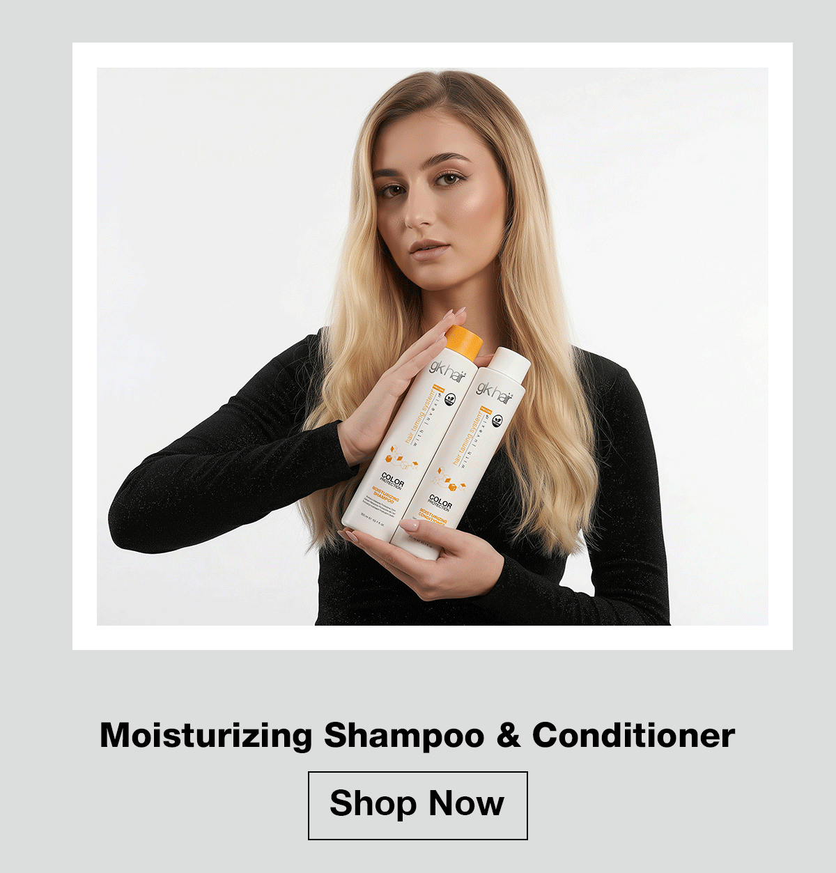 Woman holding GK Hair Moisturizing Shampoo and Conditioner