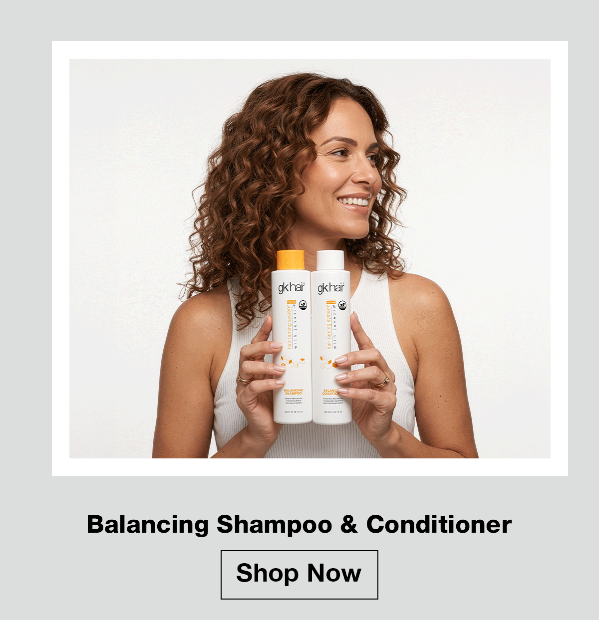 Woman holding GK Hair Balancing Shampoo and Conditioner