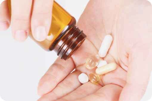 Person pouring testosterone pills into their hand