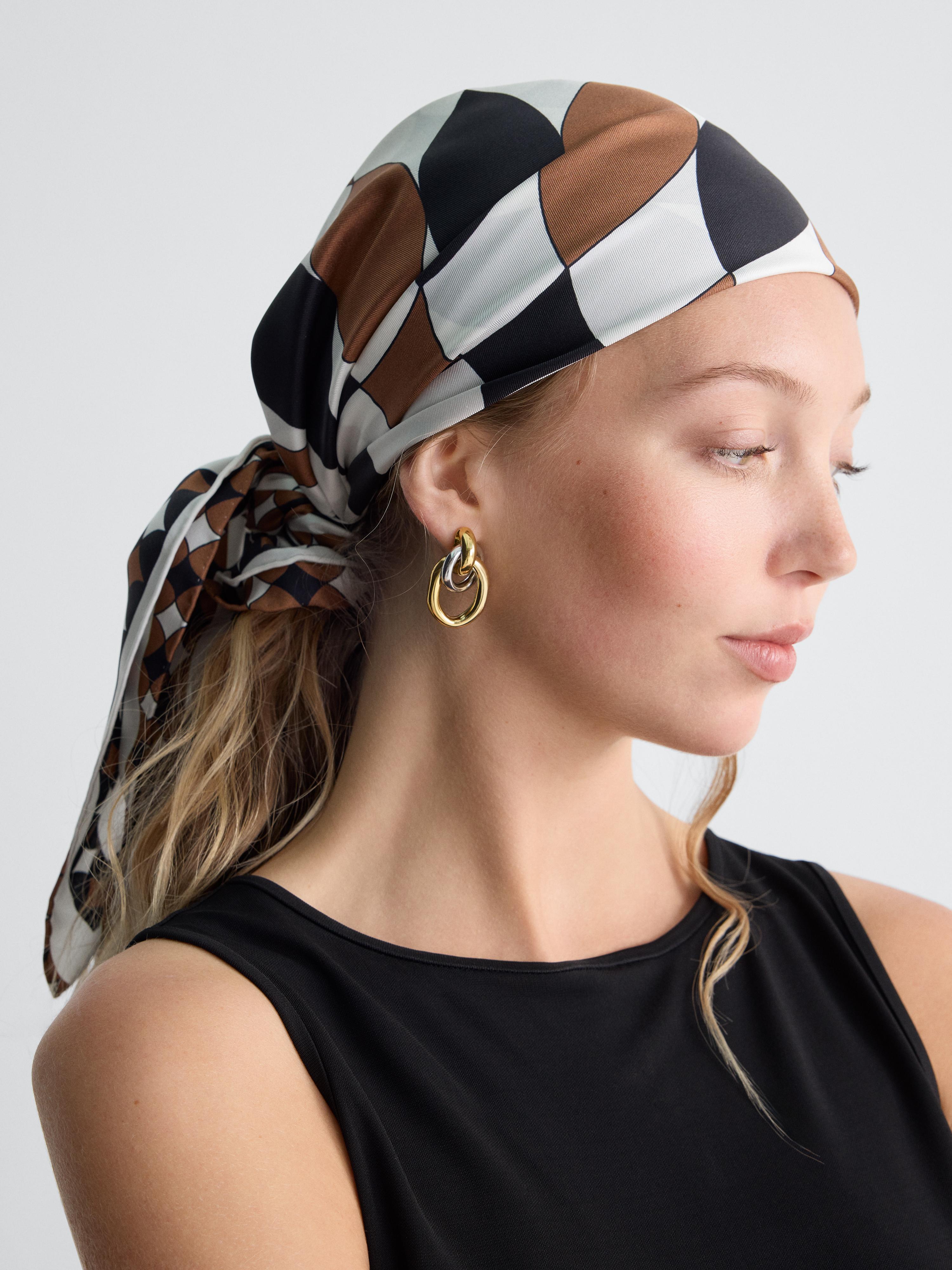 white black and brown scarf worn as a bandana