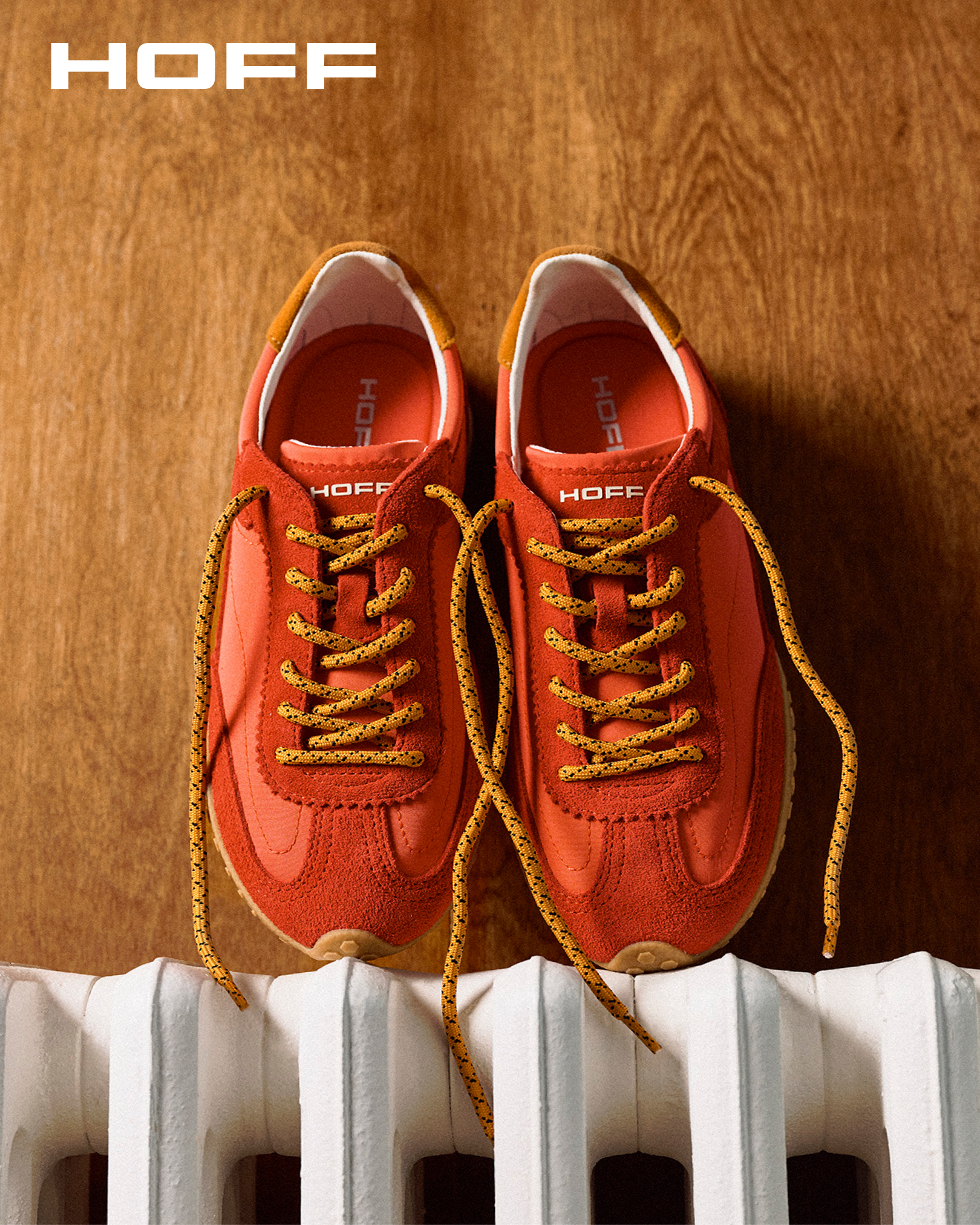 an image of a pair of orange sneakers sitting on top of a radiator