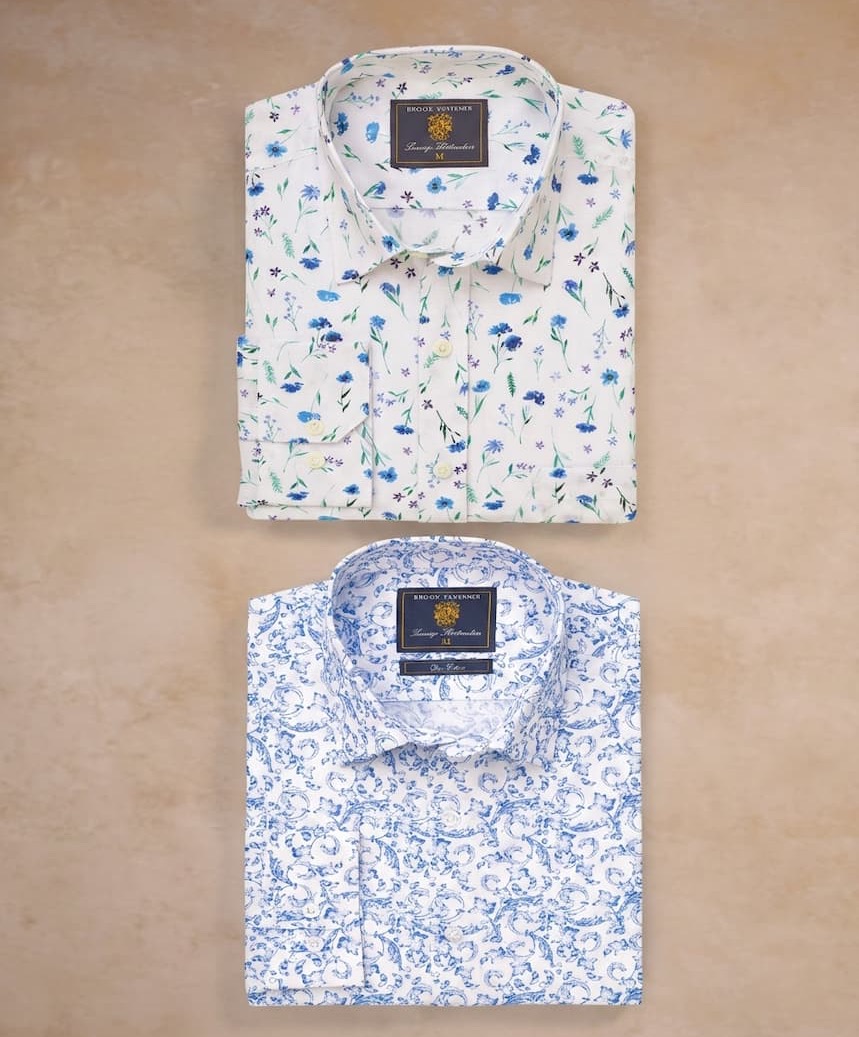 Two short-sleeved plaid button-down shirts in pastel colors are laid out on a neutral surface.