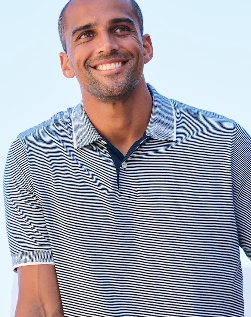 Man in a light blue polo shirt looking to the right.