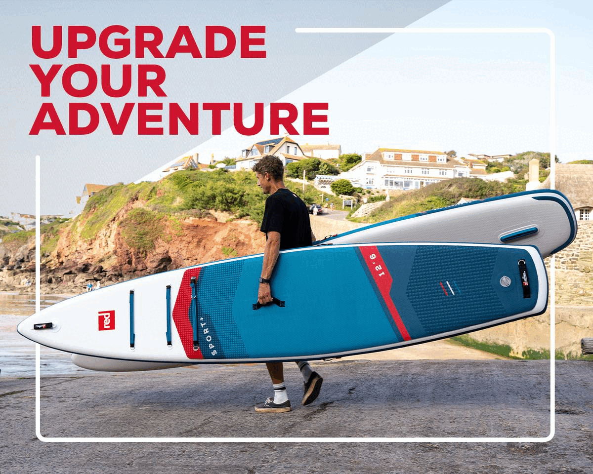 Man carrying a Red Paddle Co inflatable paddle board