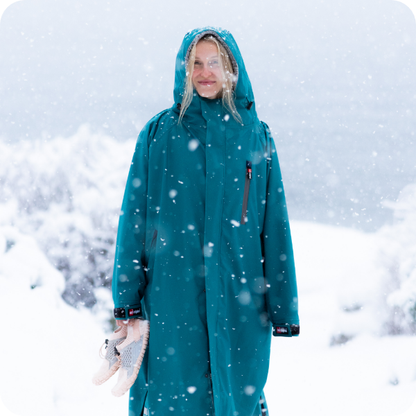 Woman in the snow wearing Red Equipment Pro Change Robe EVO in Sea Mist
