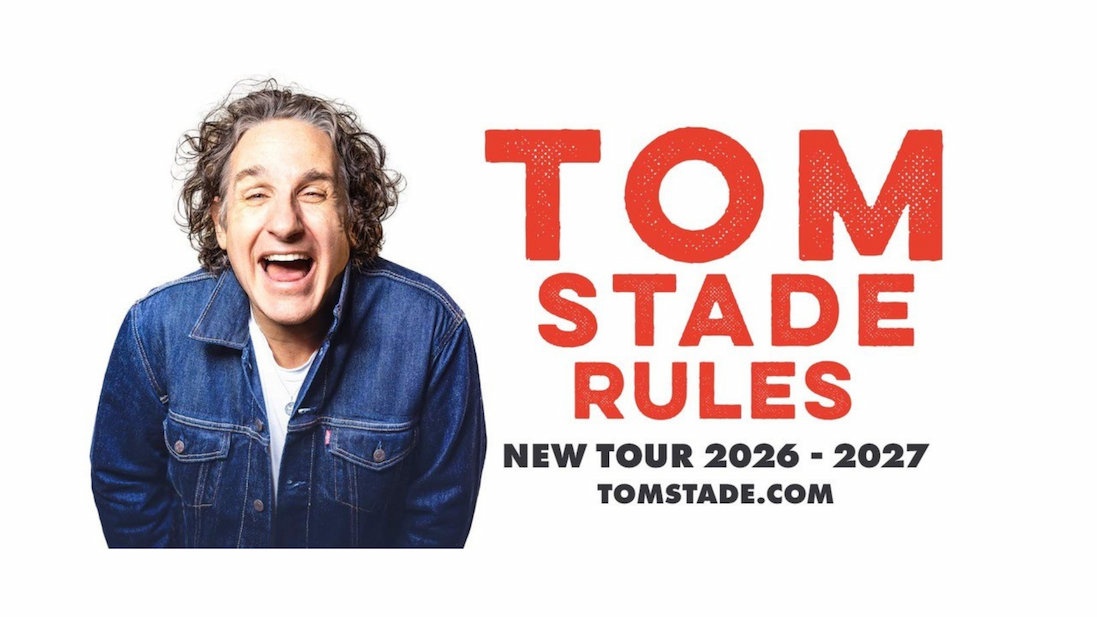 Promotional poster featuring a person with curly hair wearing a blue denim jacket against a plain light background. The person is leaning forward in a lively pose with mouth open. Bold red text on the right reads “TOM STADE RULES,” with smaller black text below stating “NEW TOUR 2026 – 2027” and “TOMSTADE.COM.”